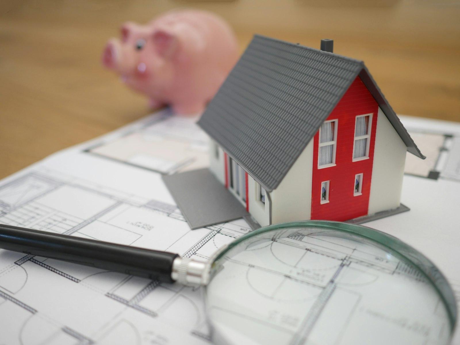 White and red wooden house beside grey framed magnifying glass