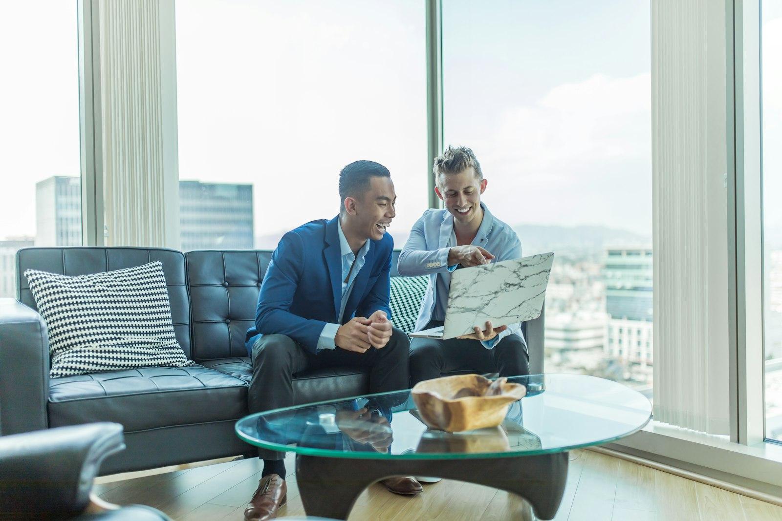 Two men in suit sitting on sofa