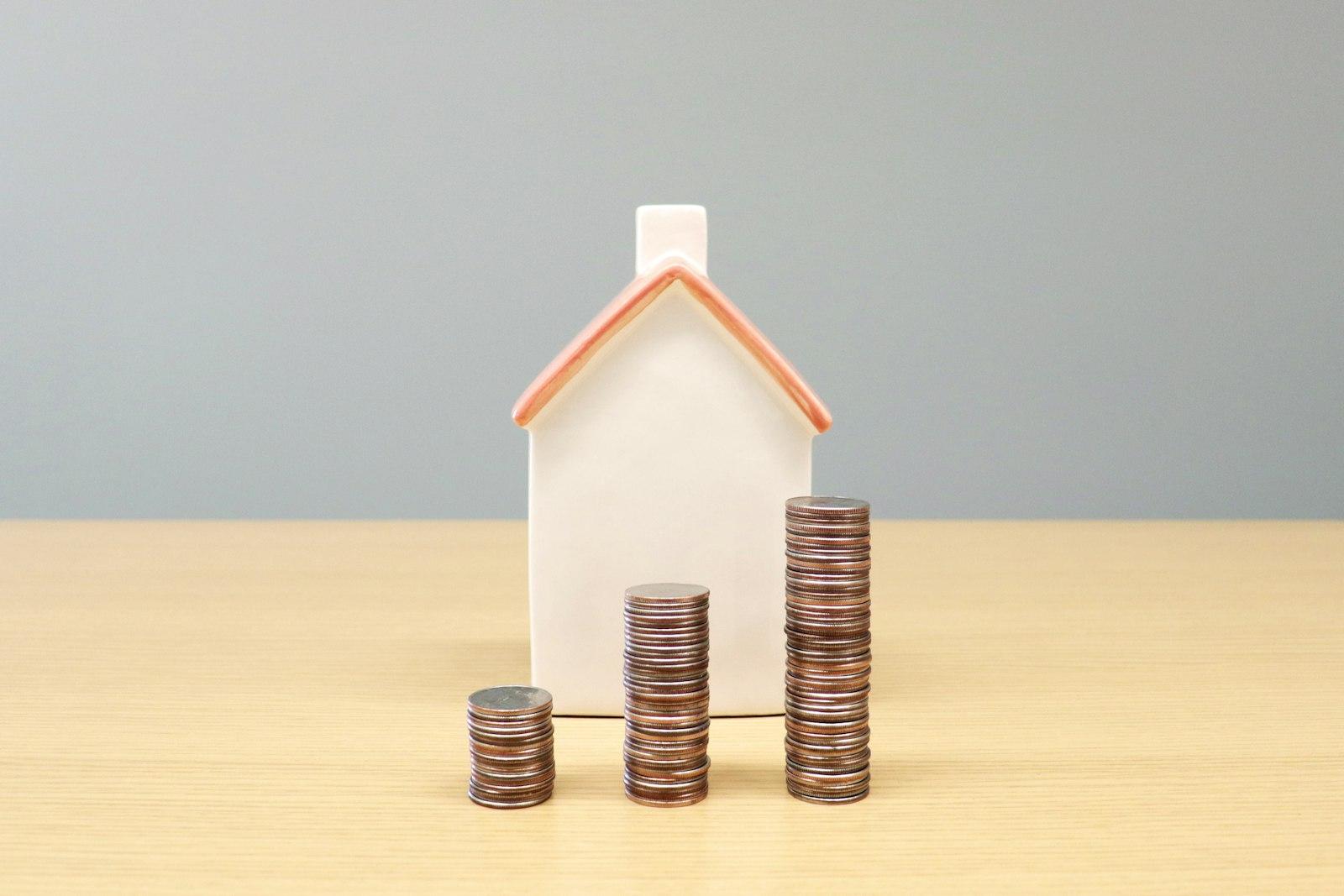 A house and stacks of coins on a table